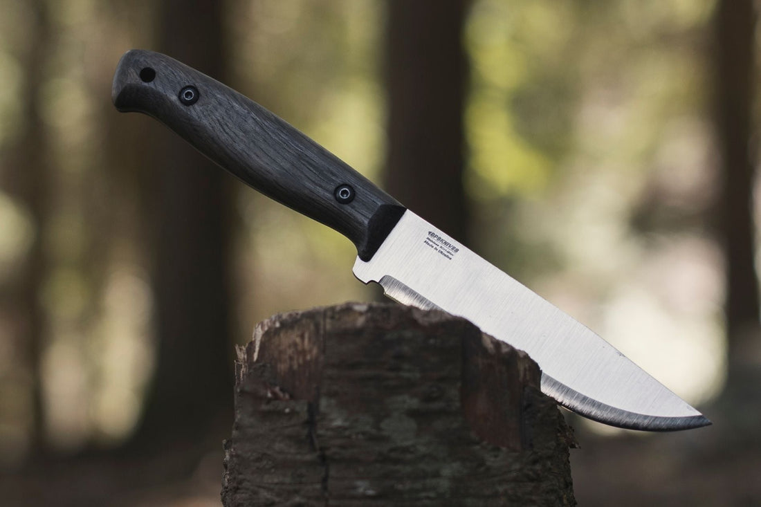 Bushcraft knife on a wooden log in the forest